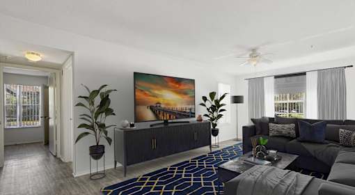 A living room with a large painting on the wall and a dark grey sofa.