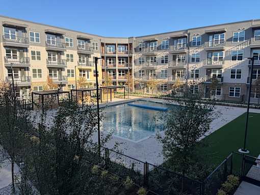 A large apartment complex with a pool in the courtyard.
