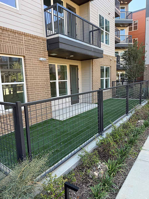 A black metal fence runs along the side of a building.