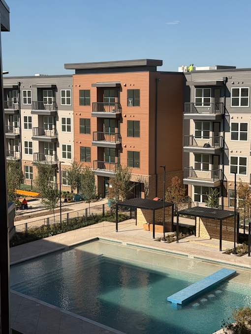 A pool in front of apartment buildings.