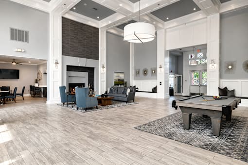 A large, well-lit room with a pool table and a fireplace.