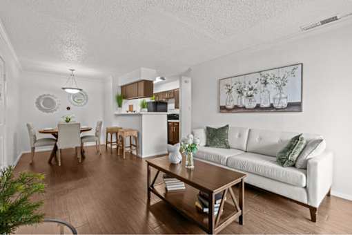A living room with a white couch and a wooden coffee table.