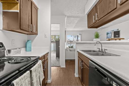 A kitchen with a black stove top oven and a black dishwasher.