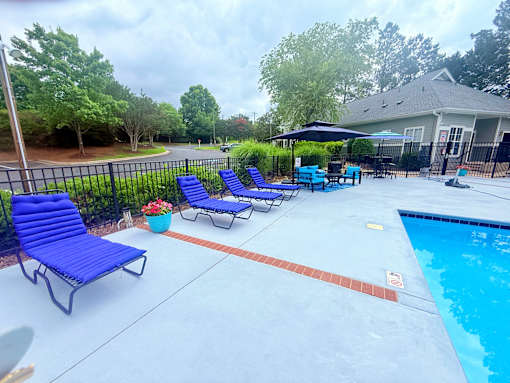 A poolside area with blue lounge chairs and a small pool.