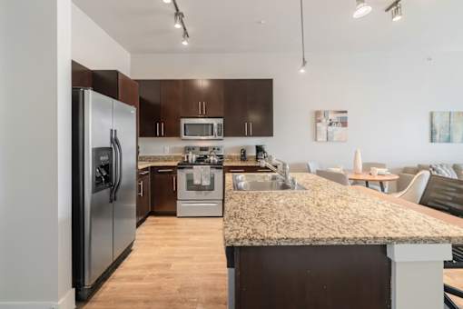 A kitchen with a granite countertop and stainless steel appliances.