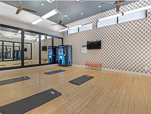 A room with wooden floors and mirrors on the wall.