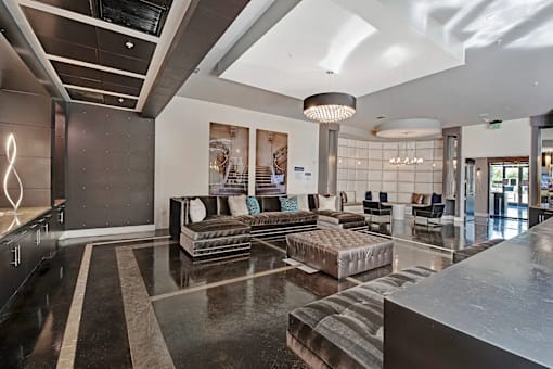 A spacious lobby with a marble floor and a large abstract painting on the wall.