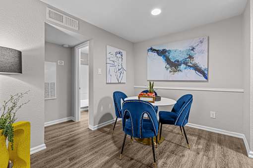 A dining room with a table and chairs.