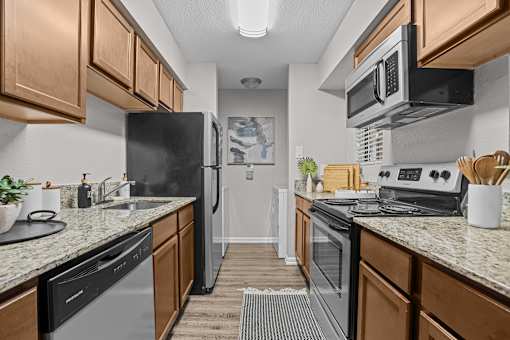 A kitchen with black appliances and wooden cabinets.