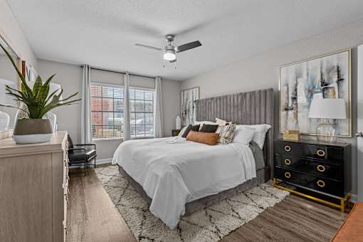 A bedroom with a large bed and a ceiling fan.