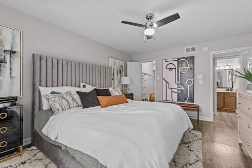 A bedroom with a large bed and a ceiling fan.