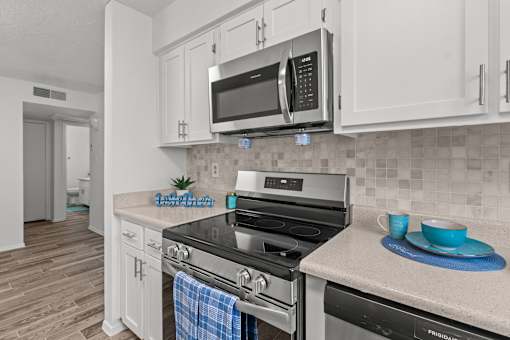 A kitchen with a stove top oven and a microwave above it.