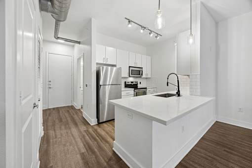 A kitchen with white cabinets and a white countertop.