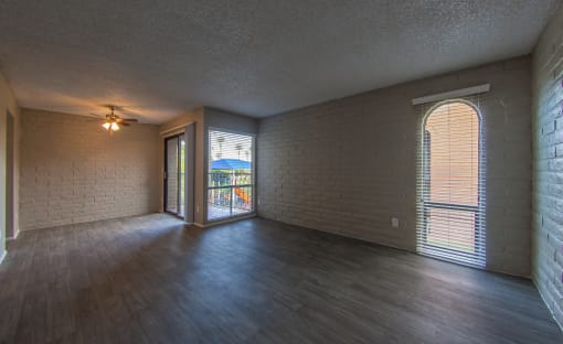 an empty living room with wood flooring and a large window
