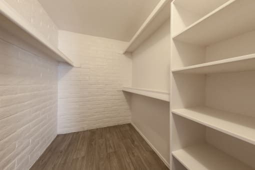 a room with white shelves and a white brick wall