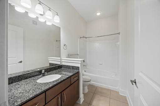 A bathroom with a sink, toilet, and bathtub.
