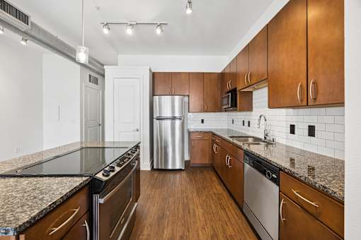 A kitchen with wooden cabinets and a stainless steel dishwasher.