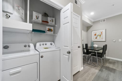 a laundry room with a washer and dryer and a dining room table with chairs