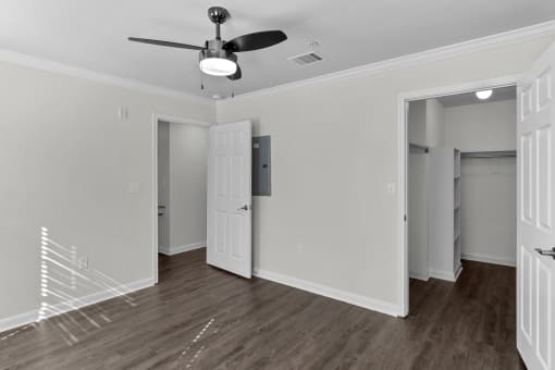 an empty room with white walls and a ceiling fan