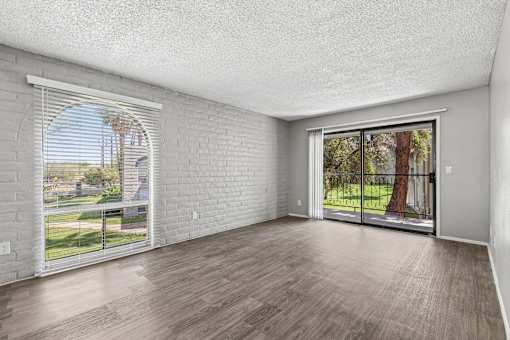 A room with a white brick wall and wooden flooring.