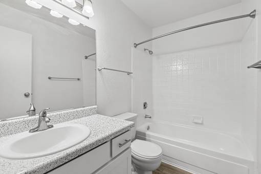 A white bathroom with a sink, toilet, and bathtub.