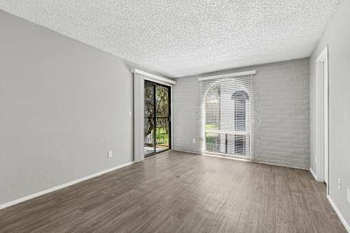 A room with a sliding glass door leading to a balcony.