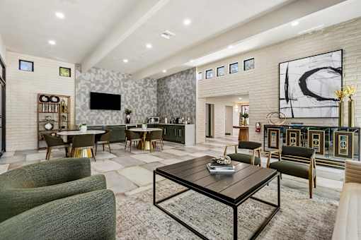 A modern living room with a black coffee table and green chairs.