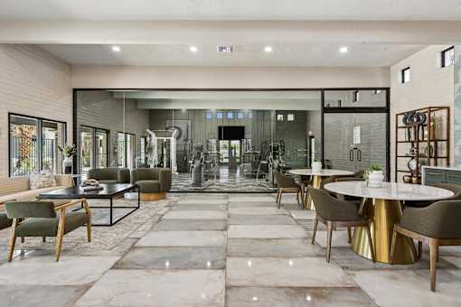 A modern dining room with a glass wall and a large table.