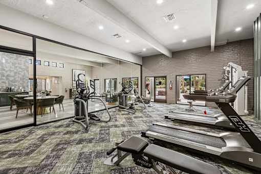 A gym with treadmills, weights, and exercise equipment.