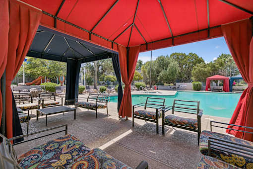 A red canopy over a poolside seating area.