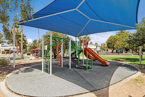 A playground with a blue canopy and a red slide.