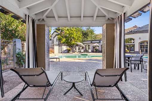 Two chairs and a table are on a patio.