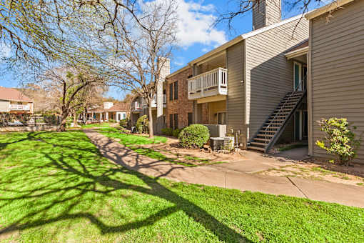 A sunny day in a quiet residential area with apartment buildings and green lawns.