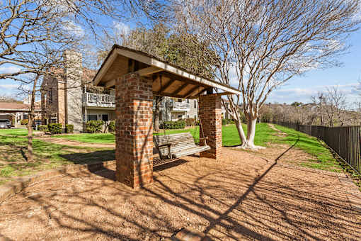 A house with a covered patio and a brick chimney.