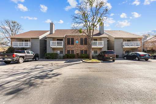A large house with a carport and a car parked in front.