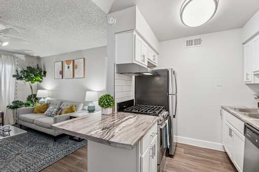 A modern kitchen with a refrigerator, stove, and sink.