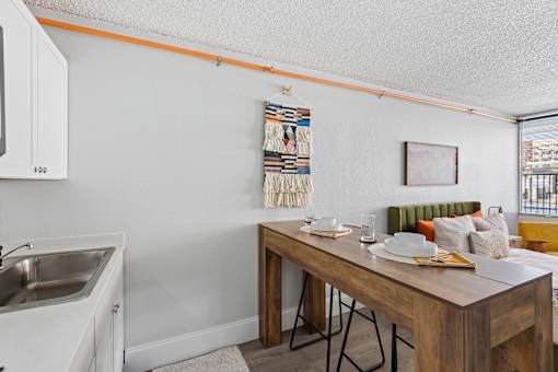 A kitchen with a sink and a dining table with chairs.