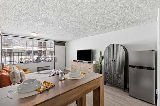 A modern kitchen with a wooden table set for a meal.
