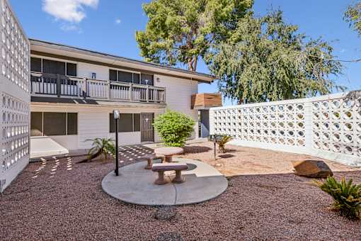 A patio area with a table and chairs in front of a building.