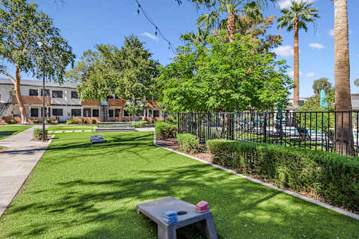 A park with a bench and a fence.
