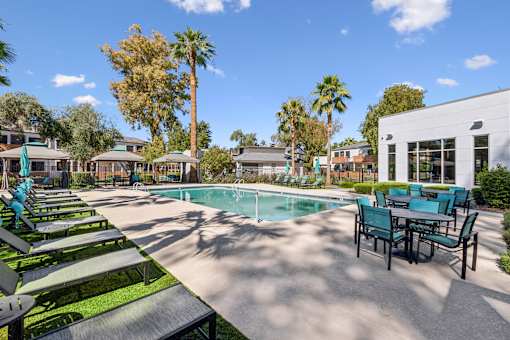 A pool area with sun loungers and a table.