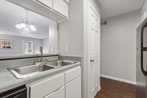 A kitchen with a sink and a refrigerator.