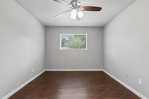Empty room with a ceiling fan and a window.