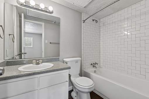 A white bathroom with a sink, toilet, and bathtub.