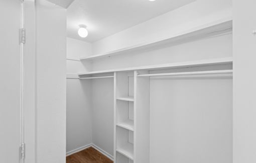 A white room with a shelving unit and a light on the ceiling.