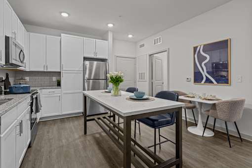 A modern kitchen with a dining table and chairs.