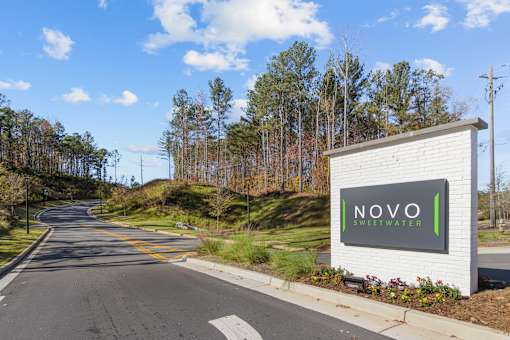 A street view of Novo Sweet Water with a white signboard.