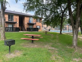 a picnic area in front of a building with a pool