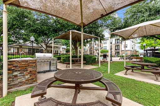 A patio with a table and chairs under a canopy.