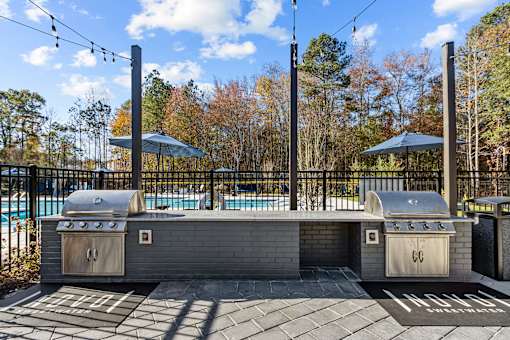 A backyard with a grill and a pool.